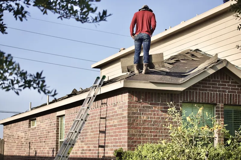 Professional roofer working on a residential roof in Bloom Center